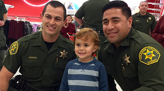 Two officers take a photo with a child