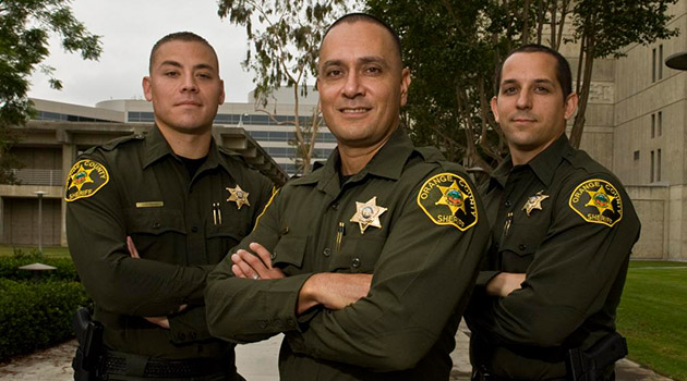 Three officers stand with arms crossed