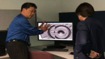 Two men viewing image on a computer monitor