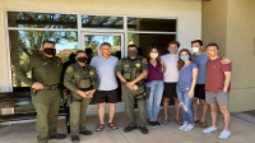 Officers pose with family of rescued Olympic swimmer