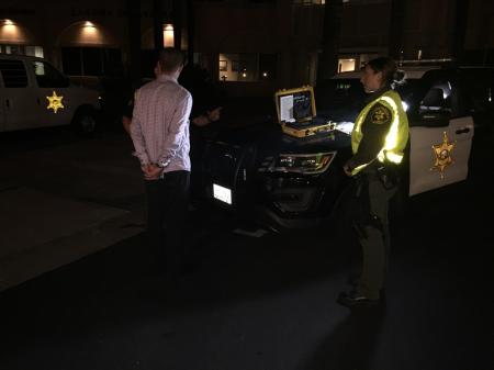 Man in handcuffs at a DUI checkpoint