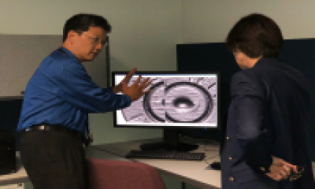 Two men viewing image on a computer monitor